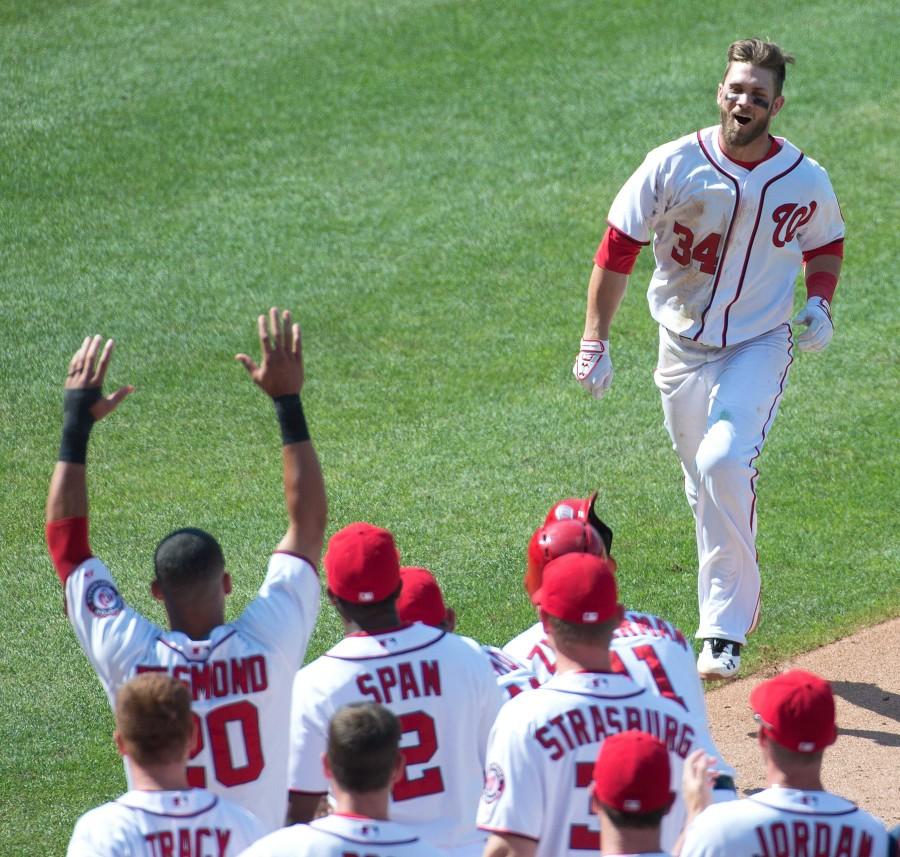 Washington Nationals left fielder Bryce Harper (34) runs to cheering teammates at home plate after hitting a walk-off, two-run home run against the Pittsburgh Pirates during the ninth inning at Nationals Park in Washington, D.C, Thursday, July 25, 2013. Washington defeated Pittsburgh 9-7.(Harry E. Walker/MCT)