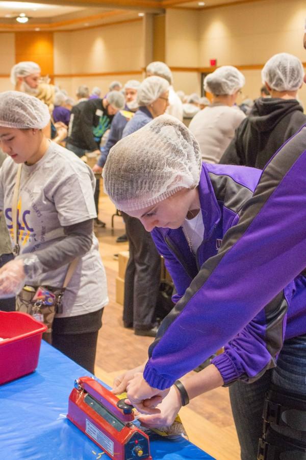 Sophomore health promotion major Ellie Herzberg seals a packaged meal. Herzberg attended the event with other members of the womens basketball team, which was one of the many campus groups to volunteer their time. 