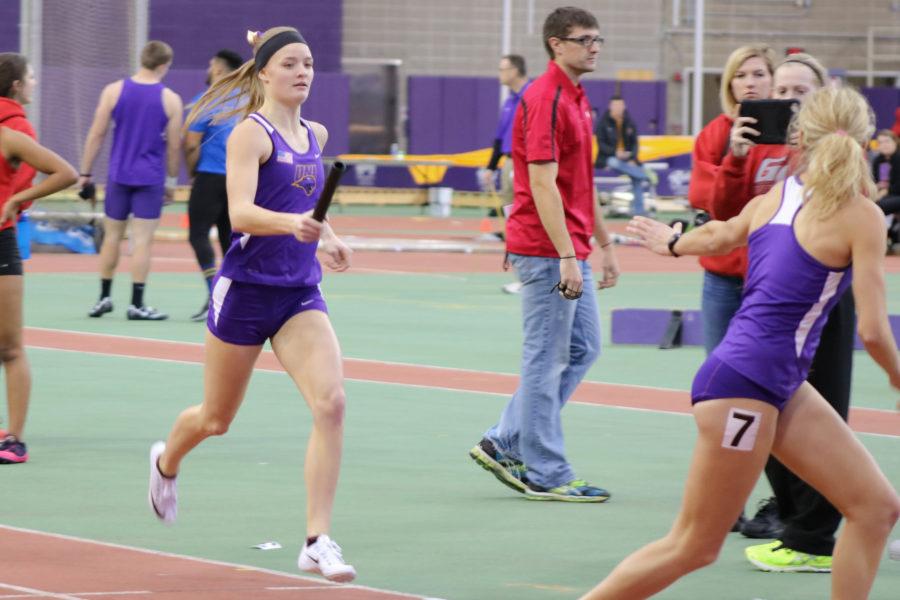 Maddie Bell (left) prepares to hand off the baton. The womens 4-x-400 team finished second behind Iowa State by half a second