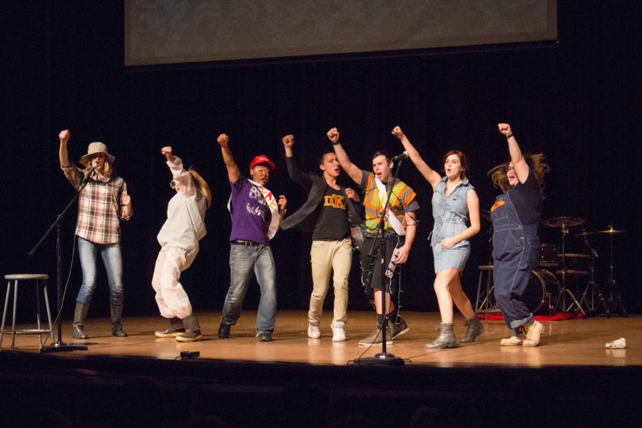 a member from each Greek organization punches a fist with enthusiasm during the talent show. The Greek god and goddess talent show showcased each Greek Life chapter