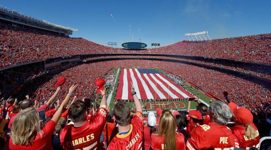 Excited football fans salute the flag just before kickoff at the Arrowhead Stadium in Kansas City, MO. The Chiefs came back and beat the San Diego chargers in the first game of the season with a final score of  33-27