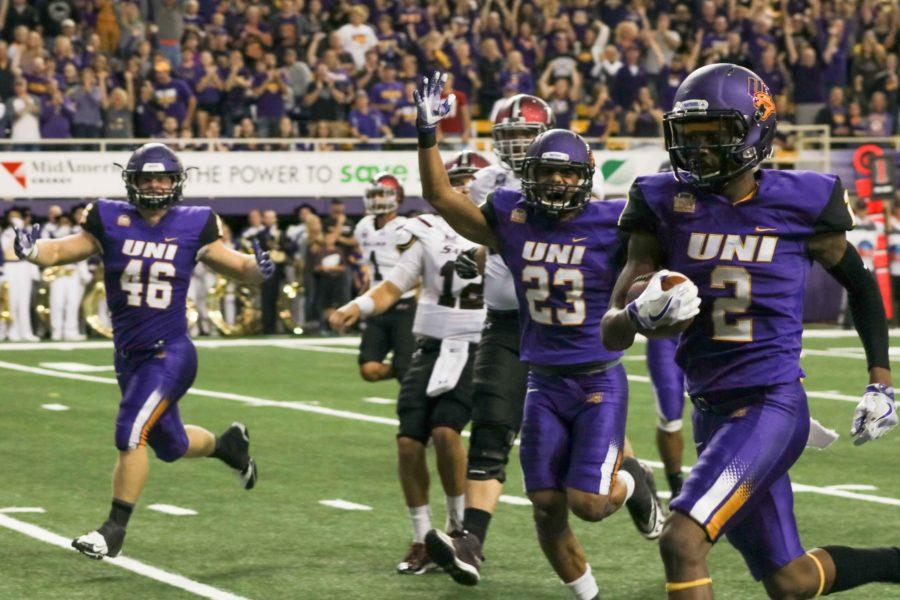 Malcolm Washington (2) is cheered on by teammates A.J. Allen (23) and Jared Farley (46) after taking his interception all the way back for another UNI touchdown. 