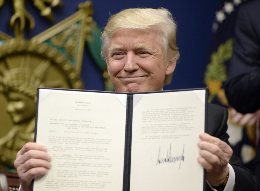 President Donald Trump holds up an executive order he has signed. Trump has signed seven executive orders in his first 10 days. Both Trump and former president Barack Obama signed five executive orders in their first week.