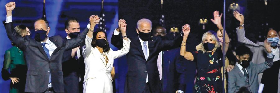 Vice President-elect Kamala Harris and President-elect Joe Biden triumphantly raise their hands after declaring victory on Saturday, Nov. 7.