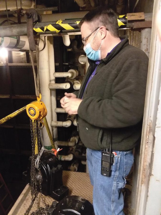 Mike Henney stands next to one of the 250 pound bearings to be installed.