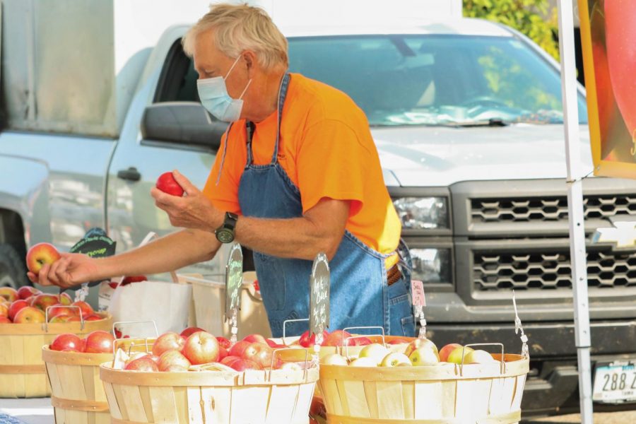 Vendor at the College Hill Farmers Market handing out food to customers. 