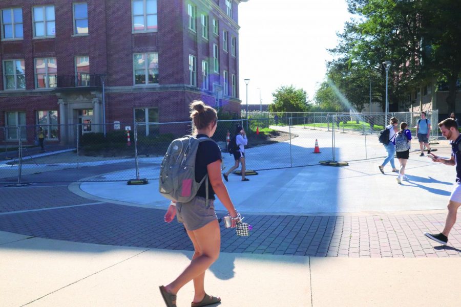 Students walk by the fence separating the construction zone on the north side of Wright Hall between classes. Construction by Wright should be done within two weeks. 