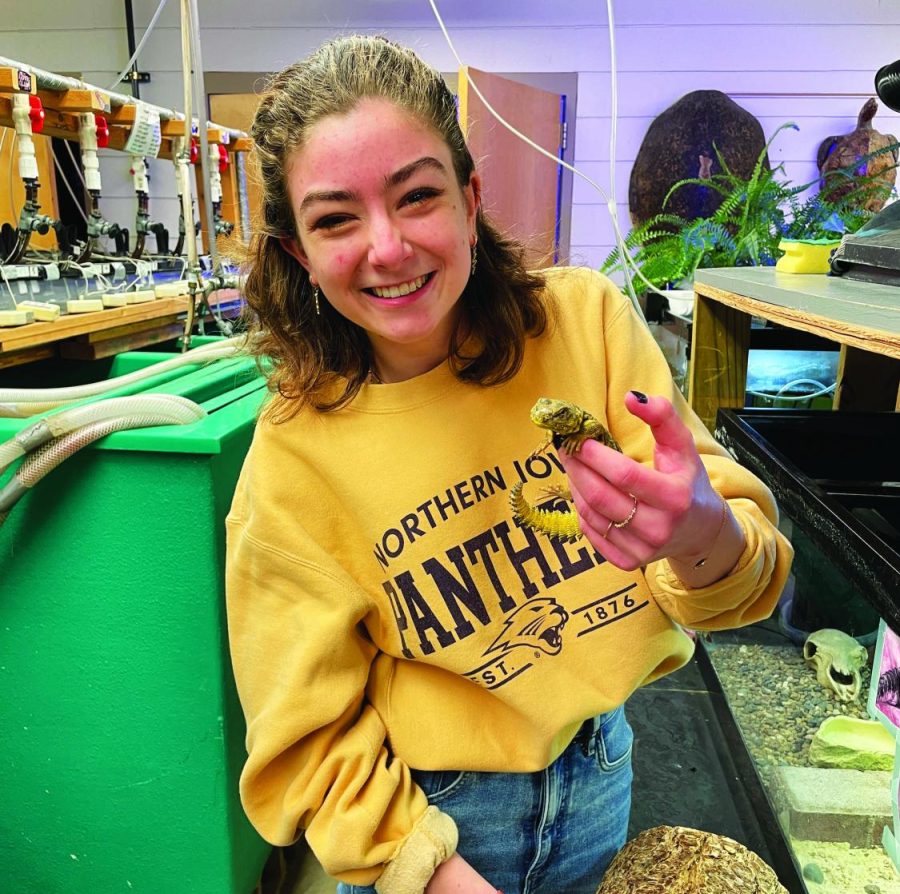 Student assistant Anna Carmen poses with a lizard in the reptile lab. Carmen has been with the reptile lab for two years.