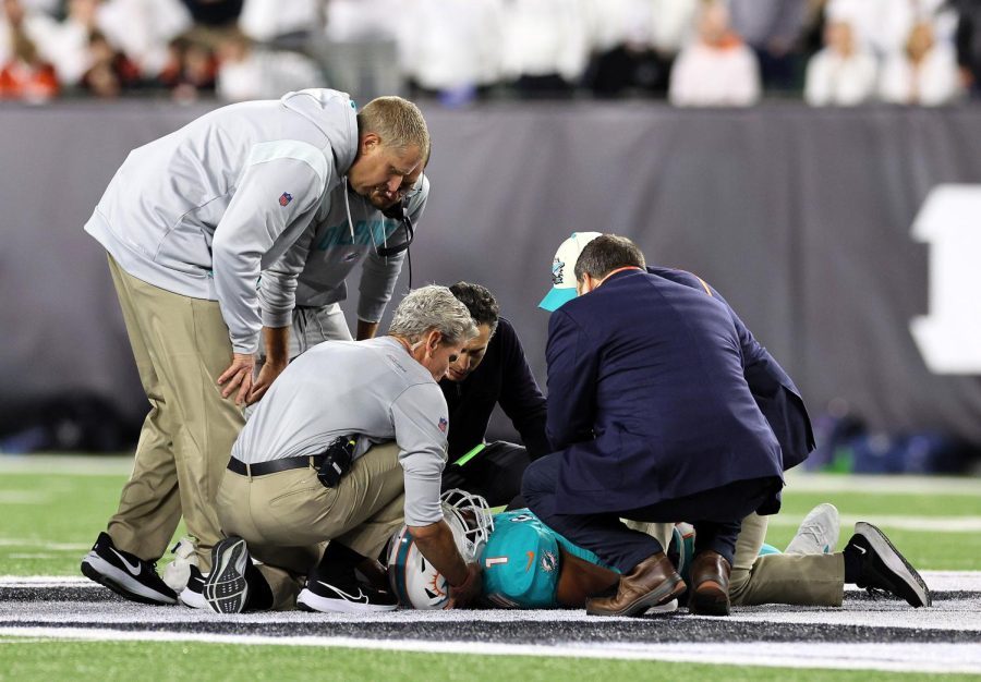 Tua Tagovailoa is checked out by doctors after receiving a concussion during Miamis game against Cincinnati on Thursday. 