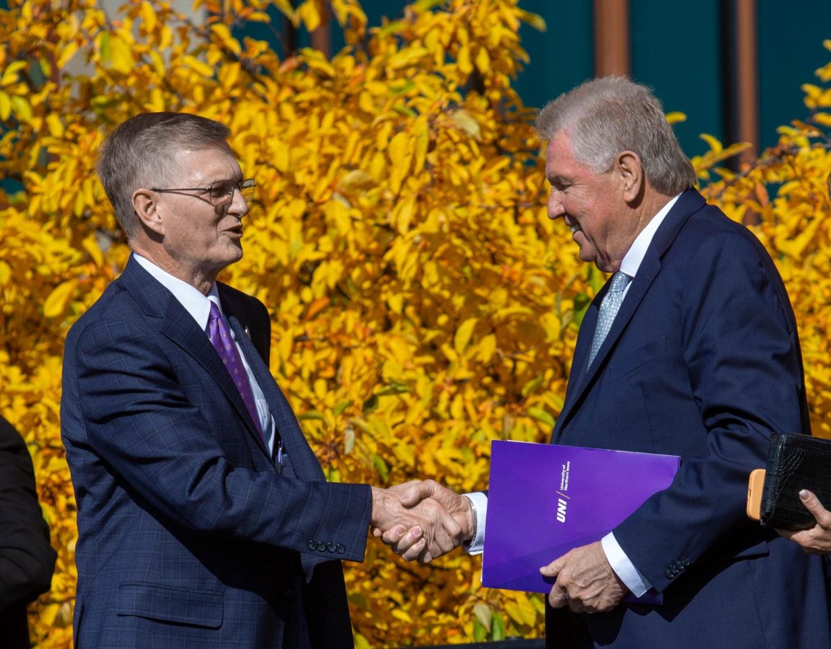 David W. Wilson shakes hands with UNI President Mark Nook at a ceremony Friday morning celebrating Wilsons $25 million donation to the College of Business.