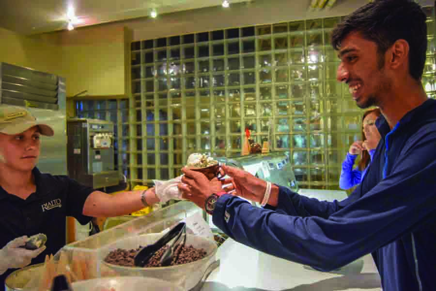 A student worker in Rialto hands ice cream to a student. Opinion columnist Estelle Johnson encourages students to be conscious of how they interact
with student workers.