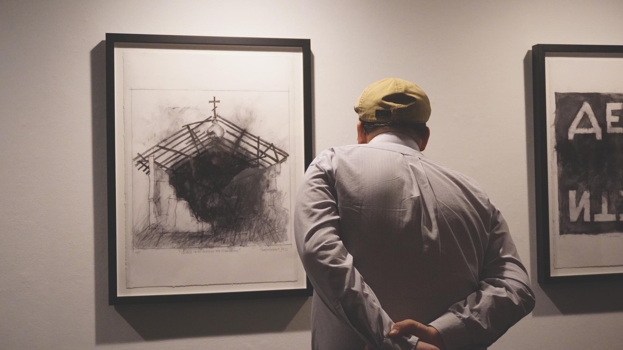 A visitor to the gallery looks upon a print of Scott Ross’s sketch “Church
of St. Nicholas the Miraculous.” The Ukrainian church was attacked by
Russian forces on Feb. 27. The print is for sale, all proceeds going to
support the Ukrainian students at UNI.