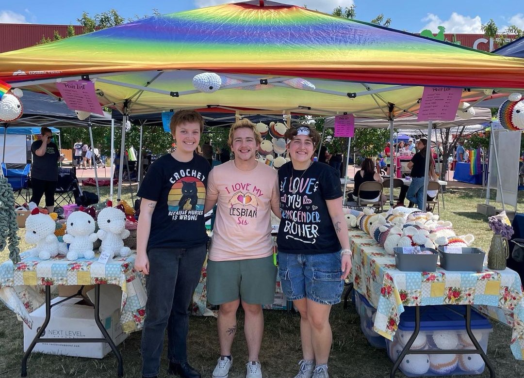 The members of TripleThread stand proudly in front of their booth at Pridefest.