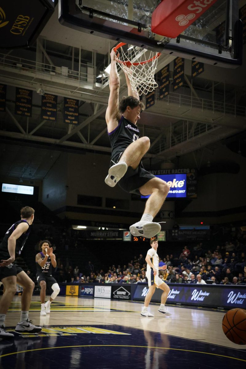 Nate Heise (0) makes a monster dunk while his team watches on.