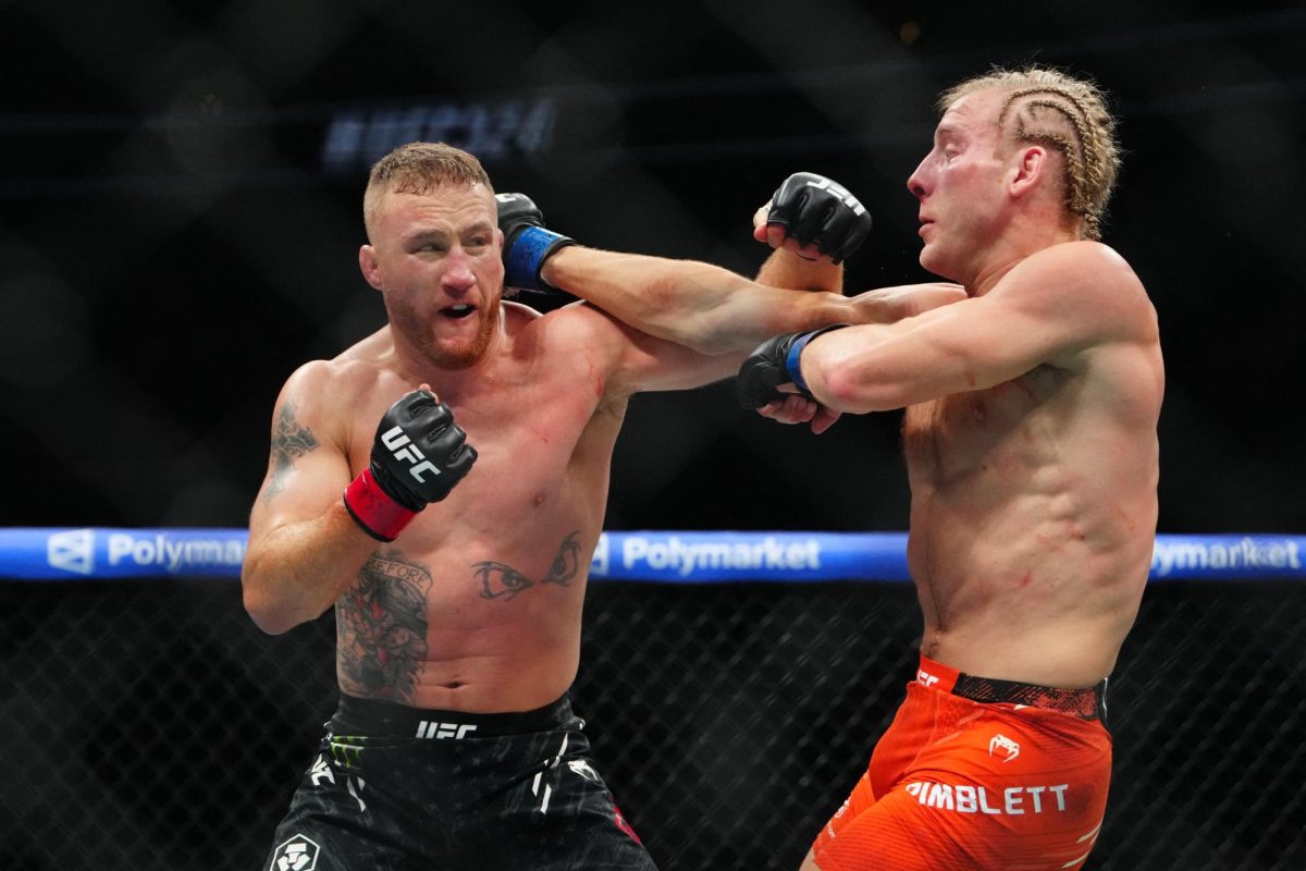 Justin Gaethje (red gloves) fights Paddy Pimblett (blue gloves) during UFC 324 at T-Mobile Arena. 