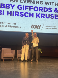 Gabby Giffords (left) and Dr. Fabi Hirsch Kruse (right) hold hands while the audience rose for a standing ovation.